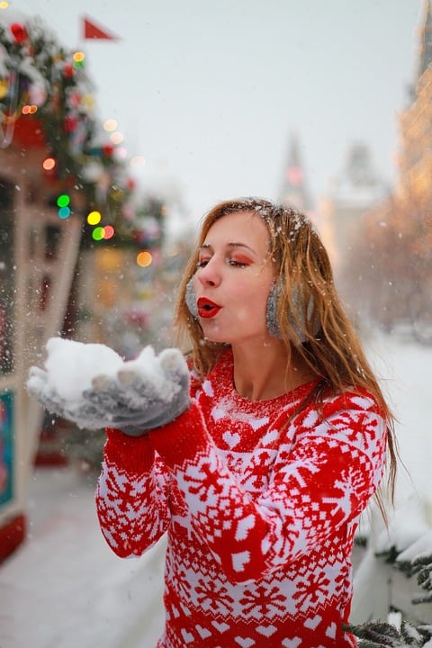 Winter Snow. Woman blowing Snow.